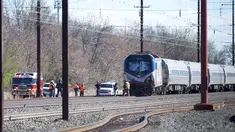 Personel darurat menyelidiki lokasi kereta Amtrak yang tergelincir setelah menabrak sebuah backhoe di dekat Philadelphia, Amerika Serikat, Minggu (3/4). Dua orang tewas dan 30 lainnya mengalami luka-luka akibat kejadian ini. (Mark Makela/Getty Images/AFP)