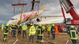 Petugas mengevakuasi pesawat Boeing 737-800 dari maskapai Pegasus Airlines yang nyaris terperosok ke dalam laut di bandara Trabzon, Turki (18/1). Dalam insiden tersebut seluruh penumpang dan awak selamat. (AP Photo / Turkay Albayak)