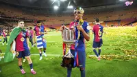 Bintang Barcelona, Lamine Yamal, berpose dengan trofi juara Copa del Rey setelah timnya mengalahkan Real Madrid dengan skor 3-2 pada laga final yang berlangsung Minggu (27/4/2025) dini hari WIB. (AP Photo/Jose Breton)