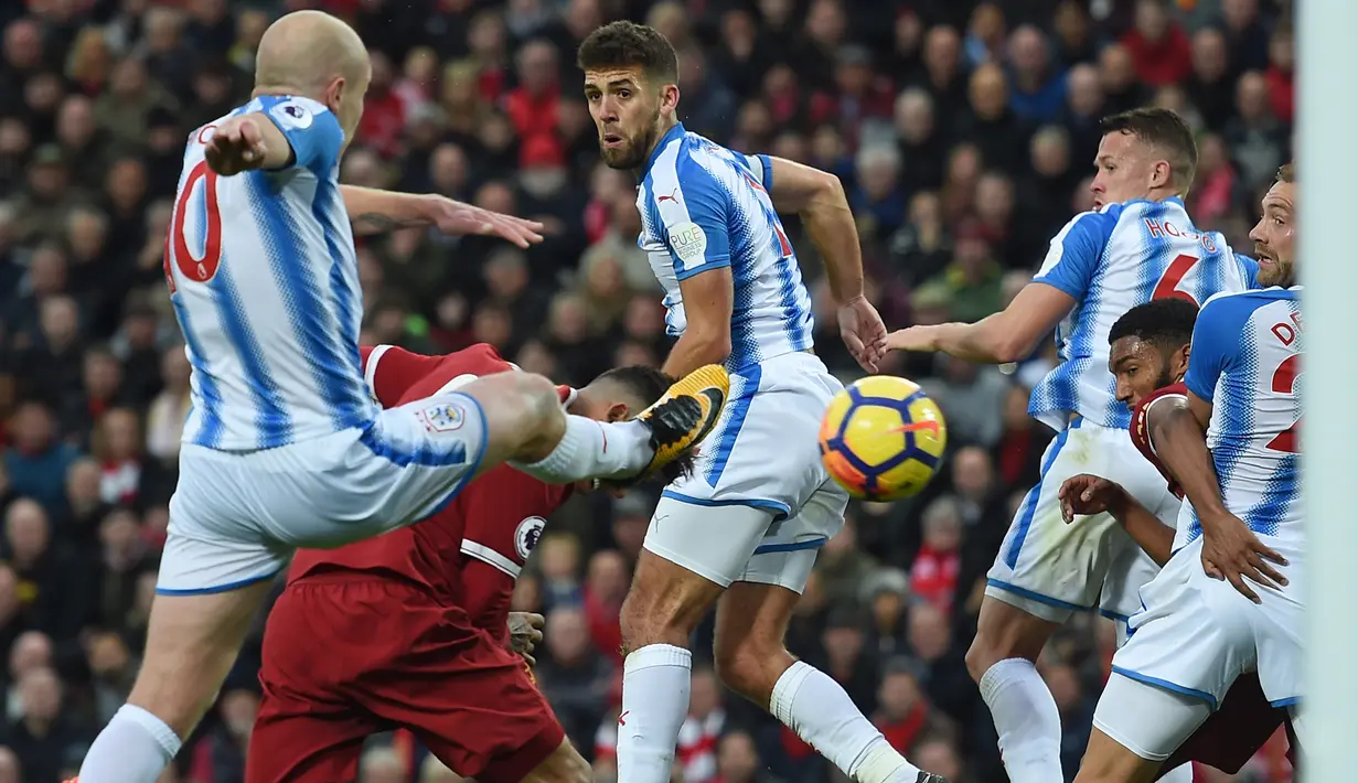 Pemain Liverpool, Roberto Firmino (2kiri) mencetak gol saat diadang para pemain Huddersfield Townt pada lanjutan Premier League di Stadion Anfield, Liverpool, (28/10/2017). Liverpool menang 3-0. (AFP/Paul Ellis)