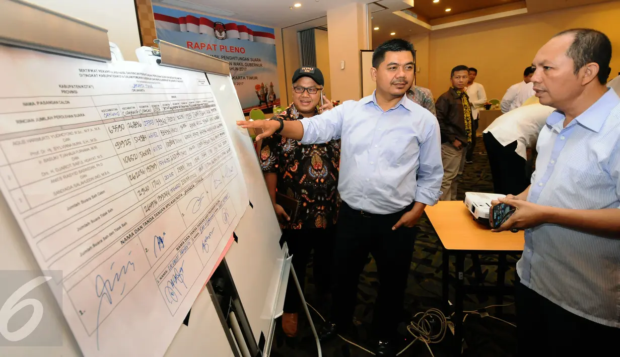 Ketua KPU RI, Juri Ardiantoro (tengah) mengecek hasil rekap Pilkada KPUD Jakarta Timur di Jakarta, Jumat (24/2). Bersama perwakilan partai politik, KPUD Jakarta Timur menggelar pleno hasil Pilkada DKI Jakarta 2017. (Liputan6.com/Helmi Fithriansyah)