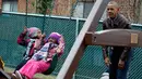 Presiden AS Barack Obama bermain ayunan dengan anak-anak dari sebuah tempat penampungan di Washington DC, AS, Selasa (16/1). Obama menyumbangkan wahana bermain milik kedua putrinya yang dipasang di luar Oval Office. (AFP PHOTO / YURI GRIPAS)