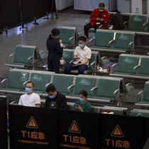 Orang-orang duduk di area tertutup sementara untuk kerabat korban pesawat China Eastern penerbangan MU5735 yang jatuh, di Bandara Internasional Baiyun, Guangzhou, Senin (21/3/2022). Ada 132 orang di dalam penerbangan tersebut, terdiri dari 123 penumpang dan sembilan awak kabin (Chinatopix Via AP)