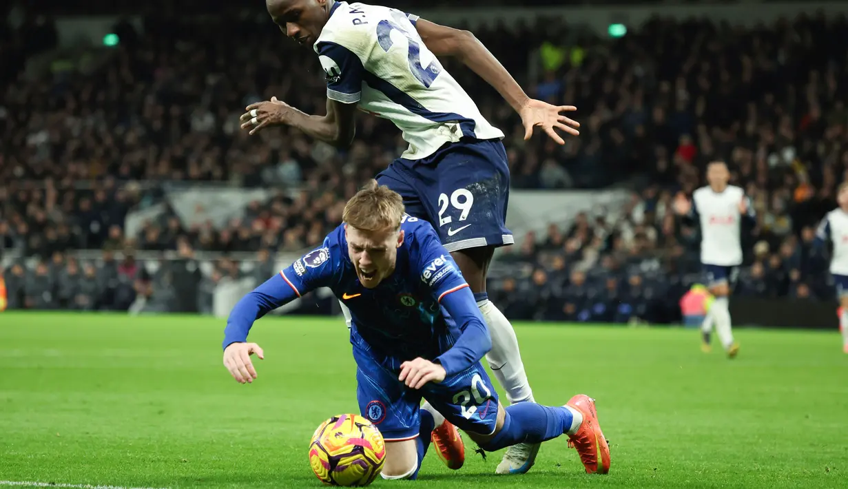 Pemain Chelsea, Cole Palmer, dilanggar pemain Tottenham Hotspur, Pape Matar Sarr, pada laga Liga Inggris di Stadion Tottenham Hotspur, Minggu (9/12/2024). (AP Photo/Ian Walton)