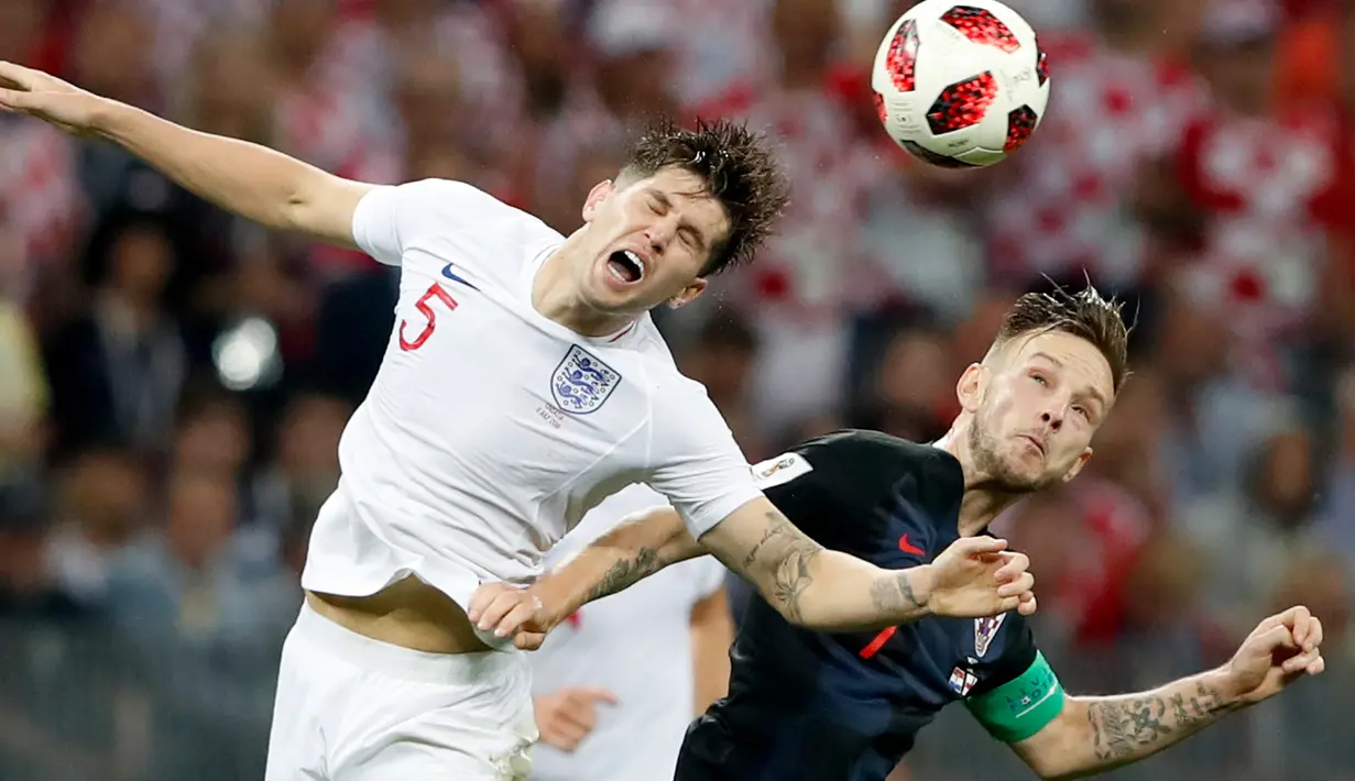 Pemain timnas Inggris, John Stones berebut bola dengan pemain Kroasia, Ivan Perisic pada babak semifinal Piala Dunia 2018 di Stadion Luzhniki, Rabu (11/7). Kroasia akan menantang Prancis di final setelah menang 2-1 atas Inggris. (AP/Rebecca Blackwell)