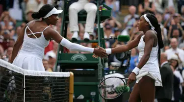 Petenis Cori Gauff bersalaman dengan Venus Williams usai pertandingan babak pertama Grand Slam Wimbledon di All England Lawn Tennis and Croquet Club, London (1/7/2019). Cori Gauff mengalahkan Venus Williams 6-4 6-4. (AP Photo/Tim Ireland)