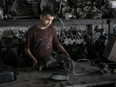Mohammed (15) menjadi seorang mekanik di Rafah, Selatan Jalur Gaza, 21 November 2016. Menurut Biro Statistik Palestina, jumlah anak yang bekerja antara usia 10-17 tahun menjadi dua kali lipat hingga 9.700 pekerja di wilayah itu. (SAID KHATIB/AFP)