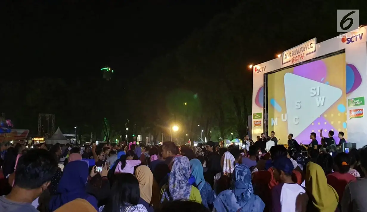 Kemeriahan acara Karnaval SCTV di Alun-Alun Bojonegoro, Jawa Timur, Sabtu (30/3). Dalam acara ini, pengunjung dapat kembali menonton film box office Indonesia Dilan 1990 yang diputar oleh SCTV. (Liputan6.com/Pool/SCTV)