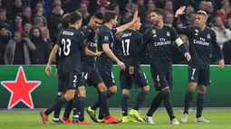 Para pemain Real Madrid merayakan gol kedua tim mereka ke gawang Ajax pada leg pertama 16 besar Liga Champions di Johan Cruijff ArenA, Amsterdam, Rabu (13/2). Real Madrid harus bersusah payah menaklukkan Ajax dengan skor tipis 2-1. (EMMANUEL DUNAND/AFP)