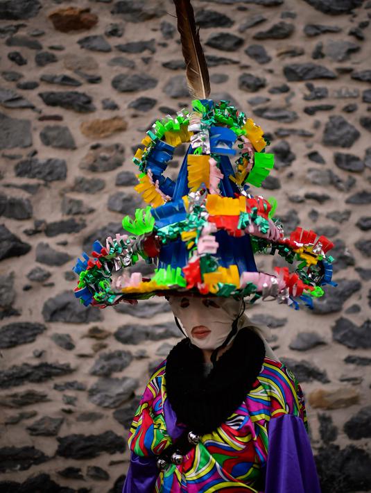 Seorang peserta mengenakan pakaian tradisional dan topi yang dikenal sebagai '' Ttutturo '' berpose di sela acara karnaval di desa Pyrenees Leitza, Spanyol (30/1). (AP Photo / Alvaro Barrientos)