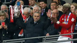 Jose Mourinho mengangkat trofi Piala Liga Inggris usai mengalahkan Southampton di stadion Wembley di London pada 26 Februari 2017. MU sukses mengalahkan Southampton 3-2. (AFP Photo/Ian Kington)