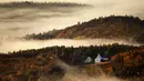 Kabut lembah berembus melalui perbukitan berwarna musim gugur di dekat Picket Hill Farm, Oxford County, Maine, Amerika Serikat, Rabu (13/10/2021). Salah satu yang paling khas dari musim gugur adalah pohon-pohon yang berubah warna sebelum gugur. (AP Photo/Robert F. Bukaty)