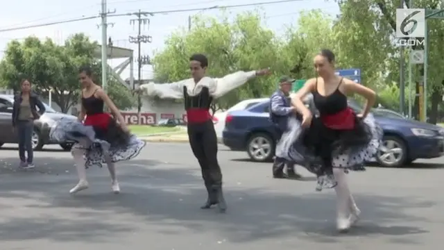 Sekelompok balerina beraksi saat lampu merah menyala di jalanan kota Meksiko. Penampilan mereka tersebut bertujuan untuk menghibur para pengendara.