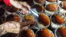 Pekerja melakukan pengemasan saat menyelesaikan pembuatan kue keranjang di Pabrik Kue Hoki, kawasan Sawangan, Depok, Jawa Barat, Jumat (26/1/2024). (merdeka.com/Arie Basuki)