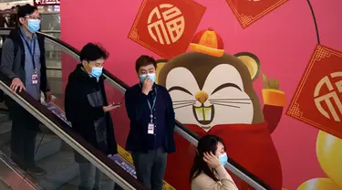 Orang-orang memakai masker saat menaiki eskalator di Bandara Internasional Hong Kong di Hong Kong, Selasa (21/1/2020). Masker terjual habis dan pemeriksaan suhu di bandara dan stasiun kereta api menjadi norma baru di China menyusul merebaknya wabah virus corona.  (AP/Ng Han Guan)