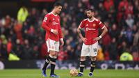Striker Manchester United Cristiano Ronaldo dan gelandang Bruno Fernandes bereaksi dalam laga Liga Inggris melawan Manchester City di Old Trafford, Sabtu, 6 November 2021. (Oli SCARFF / AFP)