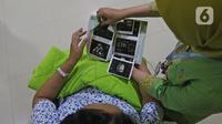 Suster menunjukkan hasil USG kandungan dari Regina (43) yang akan menjalani proses persalinan di RSUD Pasar Minggu, Jakarta, Kamis (20/2/2020). Bayi perempuan dari pasangan Regina dan Andre (47) lahir secara sesar di tanggal 20 bulan 02 tahun 2020 atau 20-02-2020. (Liputan6.com/Herman Zakharia)