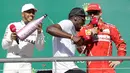 Pembalap Marcedes, Lewis Hamilton (kiri) menyiram sampanye ke mantan atlet lari cepat asal Jamaika, Usain Bolt saat merayakan kemenangannya di atas podium balapan GP Amerika Serikat di Circuit of Americas, Minggu (22/10). (AP Photo/Tony Gutierrez)