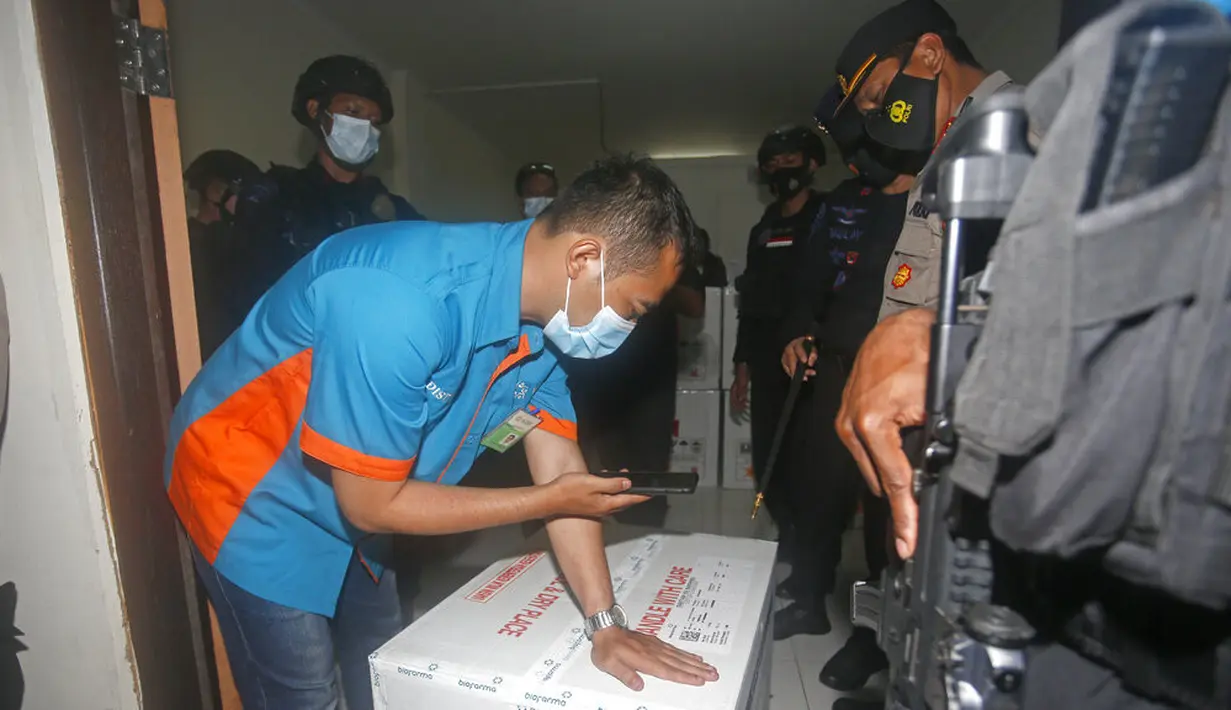 Seorang pekerja memeriksa kotak berisi vaksin virus corona COVID-19 setibanya di Bali, Selasa (5/1/2021). Dinkes Bali telah melatih lebih dari 3.000 vaksinator di Bali dan akan ditempatkan di seluruh rumah sakit, puskesmas, dan poskesdes. (AP Photo/Firdia Lisnawati)