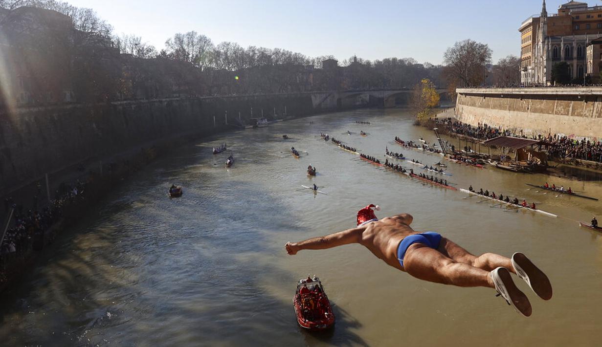 Walter Schirra dari Italia melompat ke Sungai Tiber dari Jembatan Cavour setinggi 18 meter (59 kaki) untuk merayakan Tahun Baru di Roma, 1 Januari 2022. (AP Photo/Riccardo De Luca)