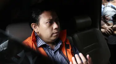 Bupati Cianjur Irvan Rivano Muchtar berada di dalam mobil usai menjalani pemeriksaan di gedung KPK, Jakarta, Kamis (13/12). Irvan terjaring OTT oleh penyidik KPK, saat bertransaksi uang  sebesar Rp1.556.700.000. (Liputan6.com/Herman Zakharia)