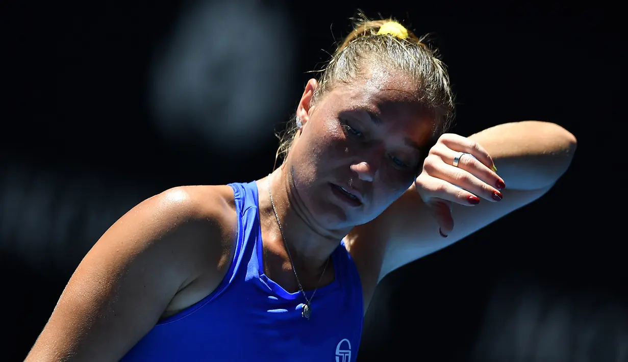 Petenis Ukraina, Kateryna Bondarenko menyeka keringat dengan tangan yang dihiasi cat kuku merah ketika melawan petenis Rusia Anastasia Pavlyuchenkova pada gelaran turnamen tenis Australia Terbuka 2018 di Melbourne, Rabu (17/1). (AFP PHOTO / Greg Wood)