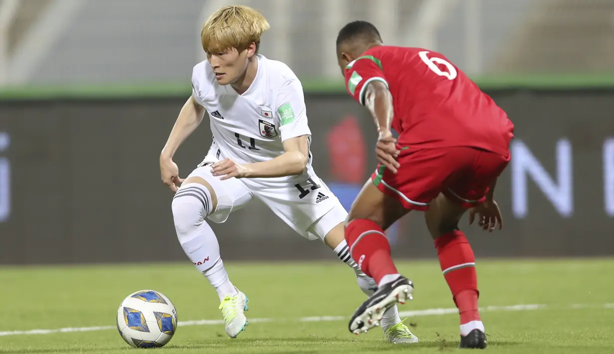 Striker Jepang, Kyogo Furuhashi berusaha melewati pemain Oman, Ahmed Al Khamisi pada pertandingan kualifikasi Piala Dunia FIFA Qatar 2022 di Sultan Qaboos Sports Complex, Muscat, Oman, Rabu (17/11/2021). Kemenangan ini membawa Jepang menuju posisi kedua klasemen Grup B. (AP Photo/Kamran Jebreili)