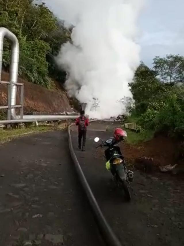 Seorang warga terpaksa menepikan kendaraannya akibat akses jalan Tasikmalaya - Garut yang berada di PGE Area Karaha terputus material longsor, sekaligus merusak fasilitas pipa uap milik perusahaan.