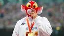 Atlet Polandia, Piotr Malachowski, menutup wajahnya dengan maskot Kejuaraan Dunia Atletik 2015 setelah meraih emas lempar lembing putra di Stadion Nasional, Beijing, Tiongkok. Minggu (30/8/2015). (Reuters/Damir Sagolj)