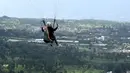 Seorang paraglider lepas landas dari lereng bukit di Puncak, Bogor, Jawa Barat, Kamis (2/12/2021). Destinasi wisata alam Bukit Paralayang Puncak Bogor sangat cocok untuk dikunjungi pada liburan akhir pekan bersama keluarga, sahabat maupun pasangan tercinta. (Goh Chai Hin/AFP)