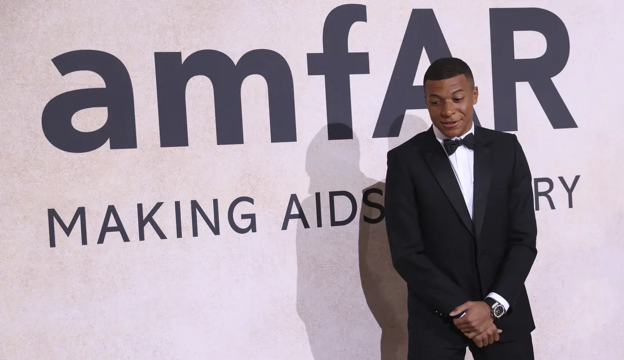 Penyerang PSG, Kylian Mbappe berpose untuk fotografer setibanya menghadiri AmfAR Cinema Against AIDS Benefit selama festival film internasional Cannes ke-75 di Hotel du Cap-Eden-Roc, Cap d'Antibes, Prancis selatan, Kamis (26/5/2022). Mbappe tampil mengenakan jas hitam berdasi kupu-kupu. (AP Photo/Vianney Le Caer)
