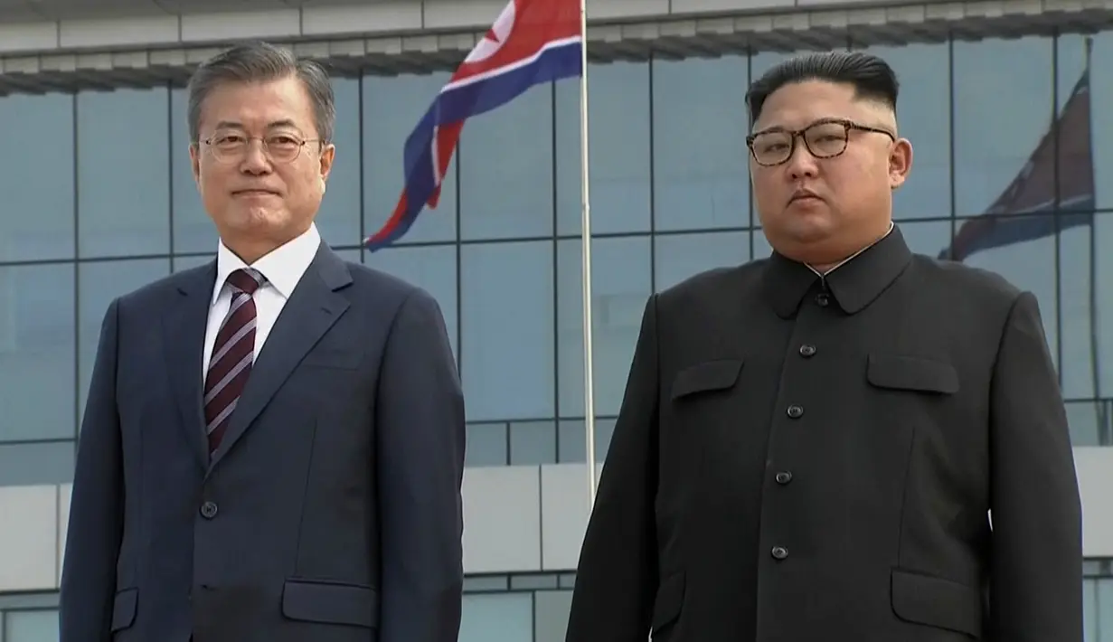 Presiden Korea Selatan, Moon Jae-in berpose dengan pemimpin Korea Utara, Kim Jong-un setibanya di Pyongyang, Selasa (18/8). Kedatangan Moon Jae-in ke negara tersebut adalah untuk pertemuan ketiga dengan Kim Jong-un. (Korea Broadcasting System via AP)