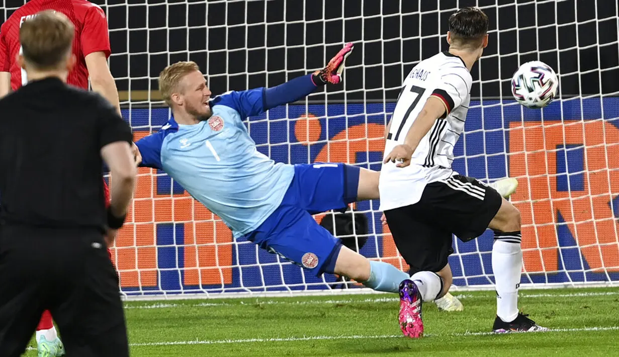 Pemain Jerman Florian Neuhaus (kanan) mencetak gol ke gawang Denmark yang dijaga kiper Kasper Schmeichel pada pertandingan persahabatan di Tivoli Stadion Tirol, Innsbruck, Austria, Rabu (2/6/2021). Pertandingan berakhir dengan skor 1-1. (Frederico Gambarini/Pool via AP)