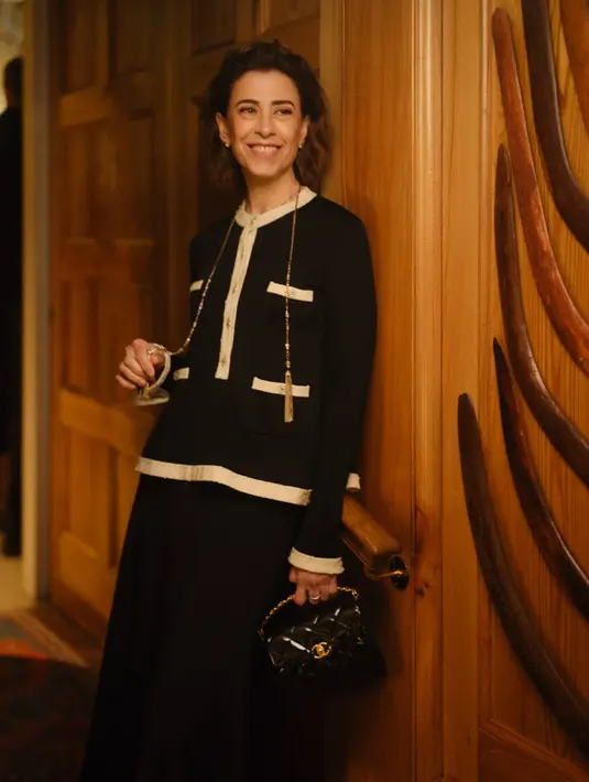 Fernanda Torres, aktris asal Brasil ini tampil memukau dengan jumper hitam ecru berhiaskan kancing perhiasan dan rok panjang lipit dalam warna senada dari koleksi Metiers d’Art 2024/25. Gaya klasiknya semakin sempurna dengan tas, sepatu, dan aksesori dari CHANEL.  [Dok/CHANEL].
