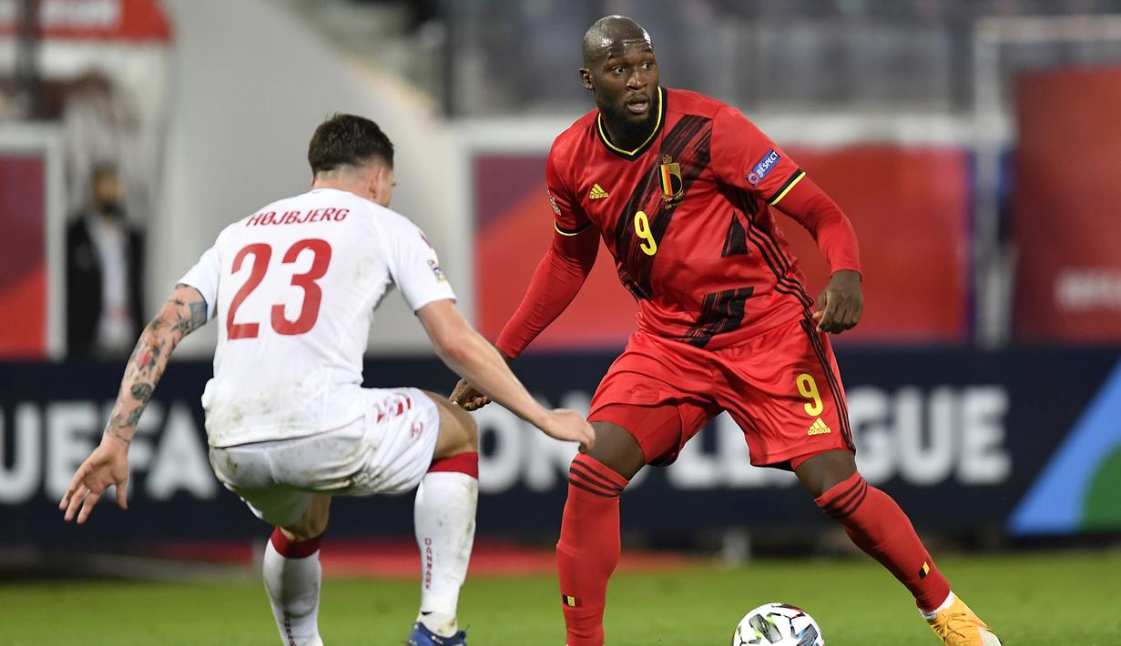 Penyerang Belgia, Romelu Lukaku, berebut bola dengan gelandang Denmark, Pierre Hojbjerg, pada laga lanjutan UEFA Nations League di Stadion Den Dreef, Kamis (19/11/2020) dini hari WIB. Belgia menang 4-2 atas Denmark. (AFP/John Thys)