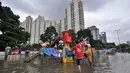 Sejumlah anak bermain di lahan bermain Kemayoran yang terendam banjir, Jakarta, Selasa (10/2). Tingginya curah hujan di wilayah Jakarta mengakibatkan sejumlah daerah masih terendam banjir. (Liputan6.com/Faizal Fanani)