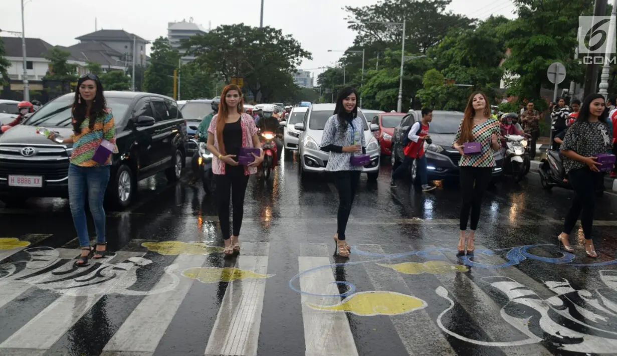 Puluhan model dari Bayu Ramli Modeling membagikan takjil di perempatan Jalan Pahlawan, Semarang, Jawa Tengah, Jumat, (18/5). Acara ini merupakan bagian dari kegiatan amal para model. (Liputan6.com/Gholib)