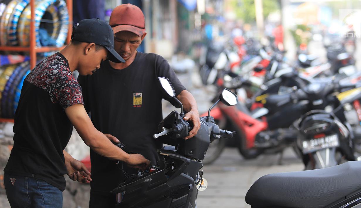 Teknisi melakukan pelayanan servis motor pelanggan di Otista, Jakarta, Minggu (10/6). Calon pemudik motor mulai memenuhi bengkel guna menyervis atau mengganti suku cadang kendaraan sebelum digunakan untuk mudik Lebaran. (Liputan6.com/Angga Yuniar)