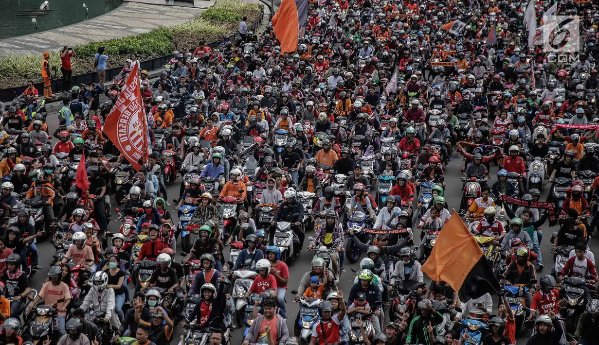 Ratusan sepeda motor suporter Persija Jakarta, Jakmania, melakukan pawai kemenangan Juara Piala Presiden di kawasan Bundaran HI, Minggu (18/2). Mereka ikut dalam larutan kebahagiaan merayakan tim kesayangan mereka juara. (Liputan6.com/Faizal Fanani)