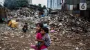 Anak-anak bermain di antara reruntuhan rumah di kawasan permukiman Jalan Pancoran Buntu II, Pancoran, Jakarta, Selasa (30/3/2021). Anak-anak yang tidak tahu permasalahan atas sengketa tanah menjadi korban dan terpaksa bermain di sisa reruntuhan tempat tinggal mereka. (Liputan6.com/Johan Tallo)
