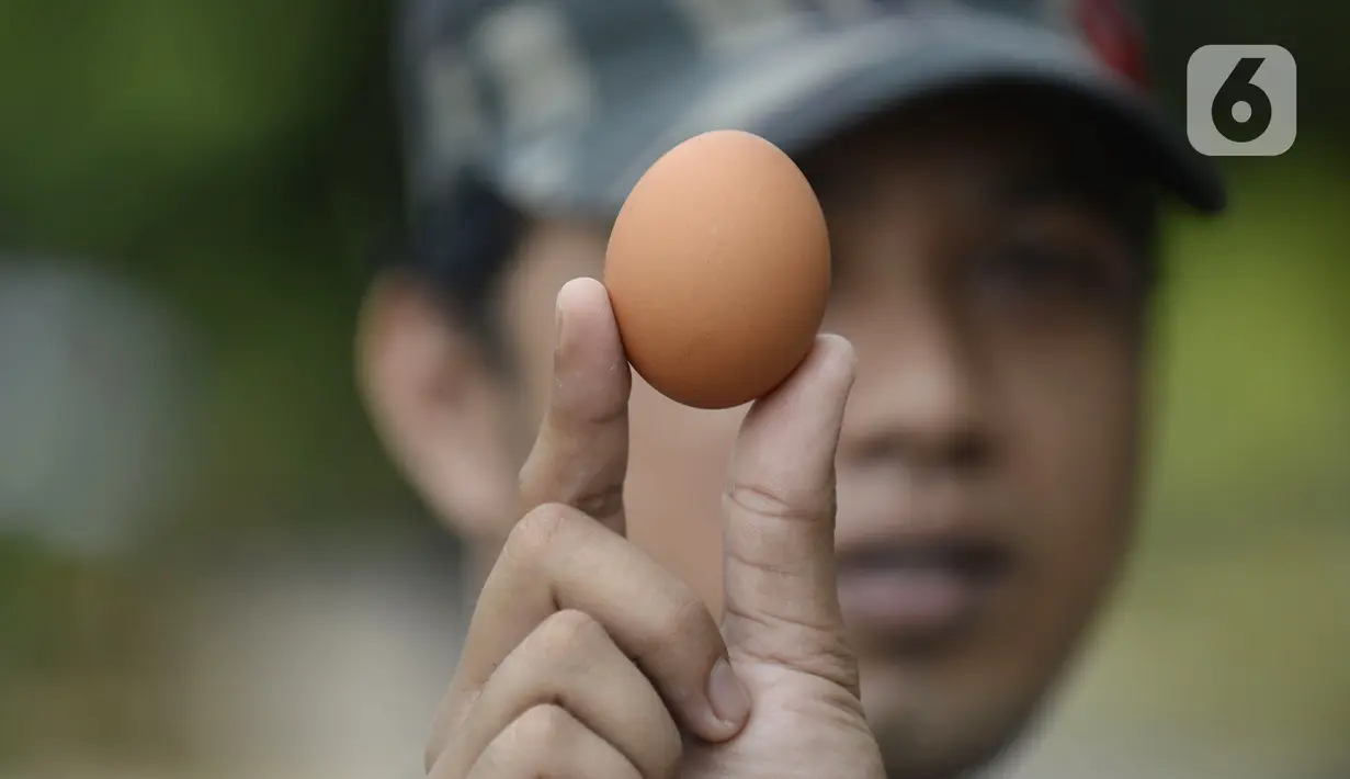 Pedagang menunjukkan telur saat berjualan di pinggir jalan kasawan Perumahan Nusa Indah, Tangerang Selatan, Banten, Jumat (22/5/2020). Jelang Lebaran, harga telur eceran terpantau masih normal. (merdeka.com/Dwi Narwoko)