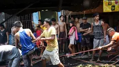 Sejumlah warga mencoba mengambil sisa kabel listrik saat insiden kebakaran sebuah pemukiman padat penduduk dekat pelabuhan di Manila, Filipina, Selasa (9/5). Mereka berebut mengumpulkan tembaga dari sisa kabel listrik. (TED ALJIBE/AFP)