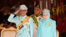 Raja Malaysia Sultan Abdullah Sultan Ahmad Shah (kiri) memberi hormat di samping Ratu Tunku Azizah Aminah Maimunah dan PM Mahathir Mohamad saat upacara pelantikannya di Istana Nasional, Kuala Lumpur, Malaysia, Kamis (31/1). (AP Photo/Yam G-Jun)