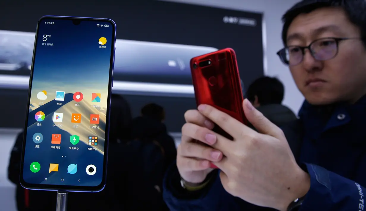 Seorang tamu undangan mencoba smartphone Xiaomi Mi 9 saat peluncuran di Beijing, China, Rabu (20/2). Sesuai rumor yang beredar, Mi 9 merupakan salah satu smartphone pertama yang resmi menggunakan Snapdragon 855. (AP Photo/Andy Wong)