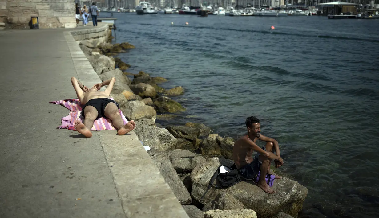 Warga berjemur saat gelombang panas di Marseille, Prancis, 15 Juni 2022. (AP Photo/Daniel Cole)