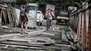 Anak anak melintasi jembatan dari kayu yang menjadi penghubung antara Jalan Karet Pasar Baru VII, Karet Tengsin dan Jalan Pam Baru, Bendungan Hilir, Tanah Abang, Rabu (30/1). (Liputan6.com/Faizal Fanani)