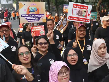 Peserta mengikuti pawai sosialisasi pengawasan Pilkada Serentak 2024 saat Hari Bebas Kendaraan Bermotor, Jalan MH Thamrin, Jakarta, Minggu (22/9/2024). (merdeka.com/Arie Basuki)
