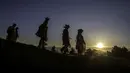 Anggota Powderkeg Morris Dancers turun dari Windgather Rocks saat matahari terbit usai melakukan festival Celtic kuno di High Peak di Derbyshire (1/5). (AFP Photo/Lindsey Parnaby)