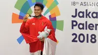 Pesilat Indonesia, Komang Harik Adi Putra menunjukkan medali emas usai memenangkan final Kelas E Putra Asian Games 2018, Jakarta, Senin (27/8). Komang menyumbang emas ke-17 Indonesia di Asian Games 2018. (Merdeka.com/Arie Basuki)