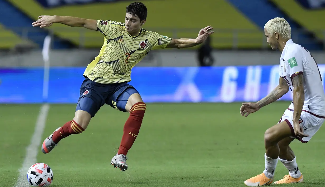 Bek Kolombia, Stefan Medina, berebut bola dengan bek Venezuela, Roberto Rosales, pada laga kualifikasi Piala Dunia 2022 zona Amerika Selatan di Estadio Metropolitano, Sabtu (10/10/2020) pagi WIB. Kolombia menang 3-0 atas Venezuela. (AFP/Gabriel Aponte/pool)